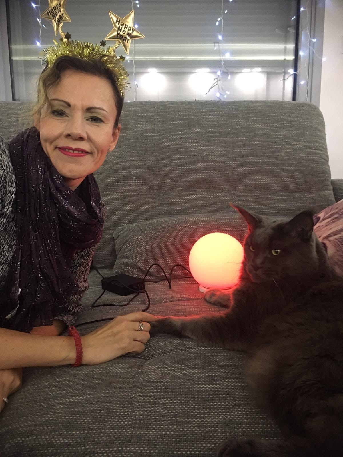 Elena at home on the sofa with one of her cats